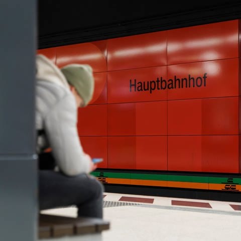 Am Stuttgarter Hauptbahnhof sitzt ein junger Mann mit seinem Handy und wartet auf einen Zug. (Foto: dpa Bildfunk, picture alliance/dpa | Julian Rettig (Symbolbild))