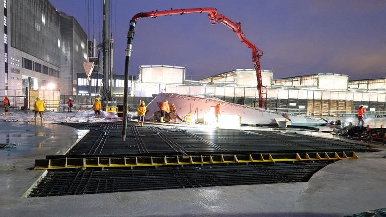Rohbau fertiggestellt: Arbeiter betonieren am frühen Morgen das letzte Stück des Daches. (Foto: dpa Bildfunk, picture alliance/dpa | Bernd Weißbrod)