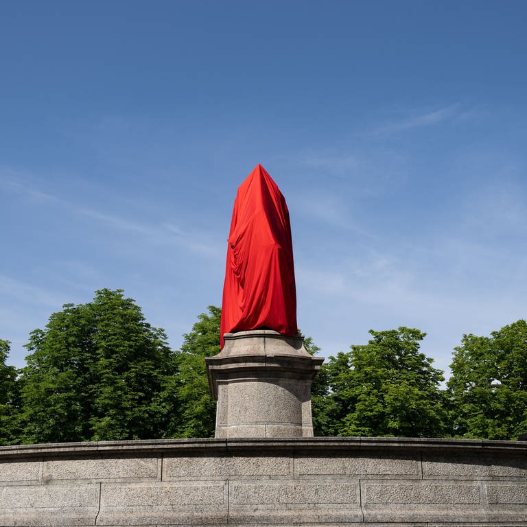 Ein Denkmal von Kaiser Wilhelm I. auf dem zentralen Stuttgarter Karlsplatz ist mit einem roten Tuch verhüllt.  (Foto: dpa Bildfunk, picture alliance/dpa | Marijan Murat)
