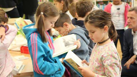 Kinder blicken in ihre Bücher (Foto: Pressestelle Kreissparkasse Esslingen)