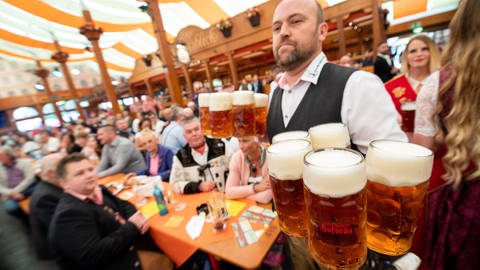 Eine Bedienung serviert auf dem Cannstatter Volksfest Bier. Gibt es dieses Jahr genügend Personal? (Foto: dpa Bildfunk, picture alliance/dpa | Sebastian Gollnow)