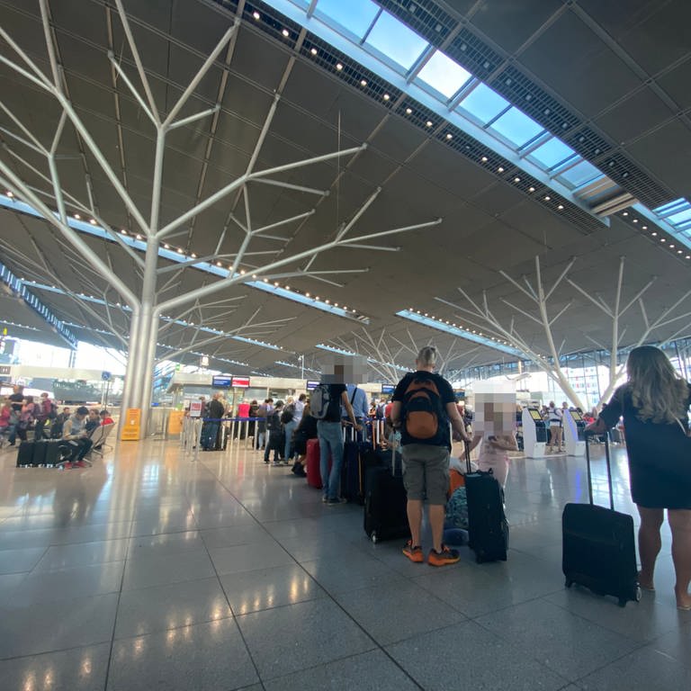 Fluggäste stehen in einem Terminal des Stuttgarter Flughafens. (Foto: SWR, SWR/Diana Hörger)