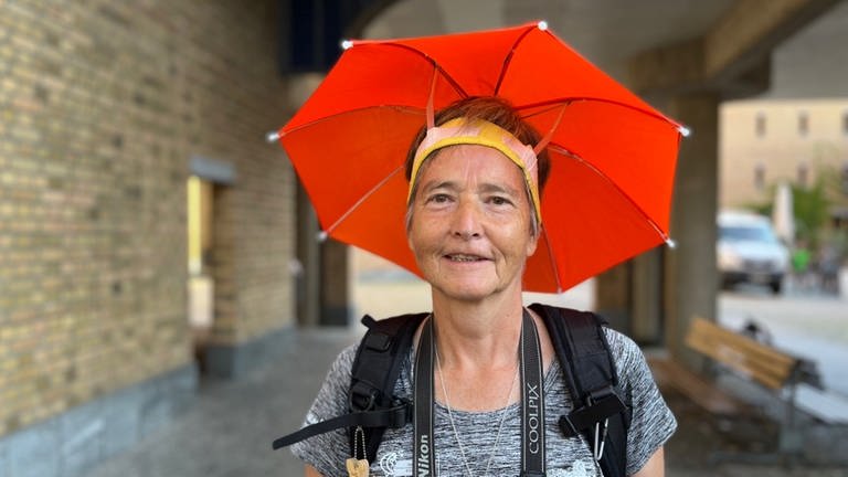 Hitzeschutz nach holländischer Art: Angelika Steinborn wandert beim Deutschen Wandertag mit Schirmchen auf dem Kopf. (Foto: SWR, Siri Warrlich)