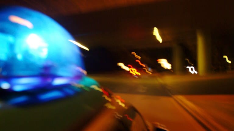 Streifenwagen bei einer naechtlichen Alarmfahrt mit Blaulicht.