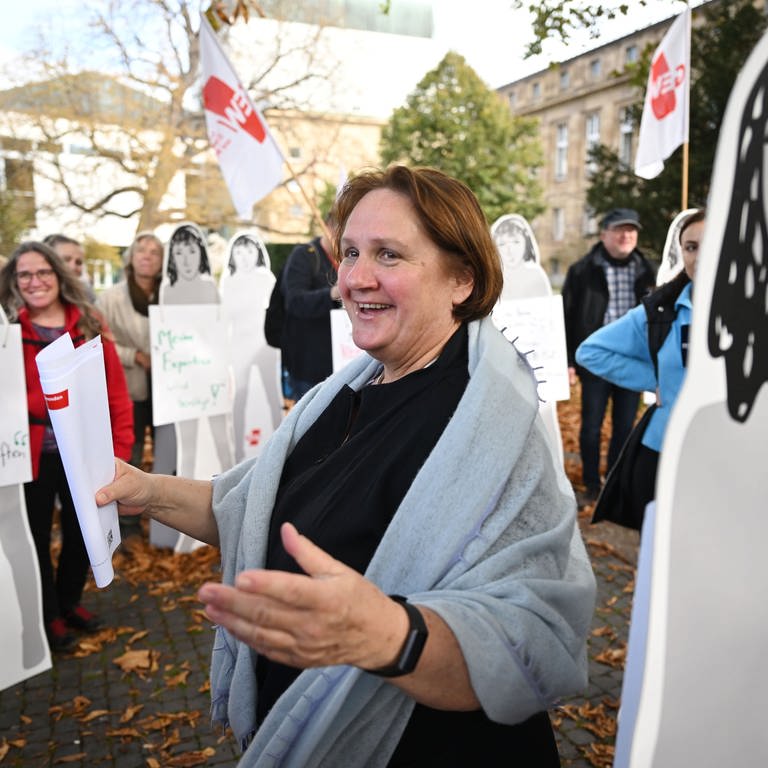 Bildungsministerin Schopper (Grüne) steht vor Teilnehmern einer Protestaktion der GEW Baden-Württemberg in der Nähe des Landtags.