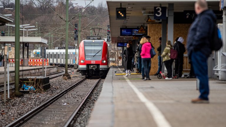 Fahrgäste warten am Bahnhof Stuttgart-Bad Cannstatt auf eine einfahrende S-Bahn.