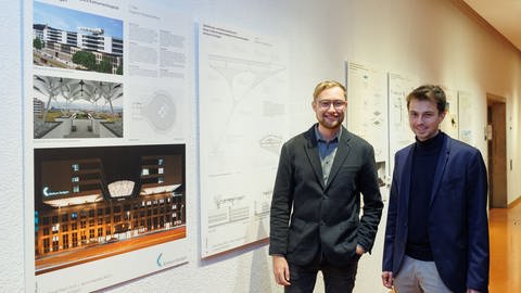 Jannis Haueise (im Bild links) und Daniel Pauli (rechts) studieren an der Uni Stuttgart und haben den neuen Hubschrauberlandeplatz für das Klinikum Stuttgart entworfen. Im Bild zeigen sie ihren Entwurf. (Foto: Pressestelle Klinikum Stuttgart)