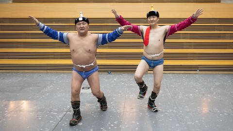 Mongolische Ringer in traditioneller Bekleidung führen bei einem Fototermin der CMT 2023 einen Adlertanz vor. Die Mongolei ist in diesem Jahr Partnerland der großen Reisemesse in Stuttgart. (Foto: dpa Bildfunk, picture alliance/dpa | Marijan Murat)
