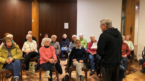 Eine Gruppe Seniorinnen und Senioren hört einem Vortrag zu (Foto: SWR)