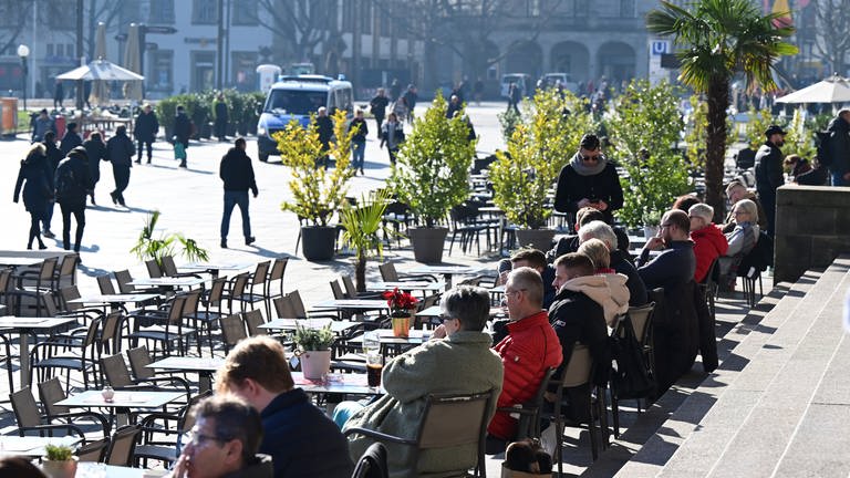 Menschen sitzen in Stuttgart in einem Straßencafe. (Foto: dpa Bildfunk, Picture Alliance)