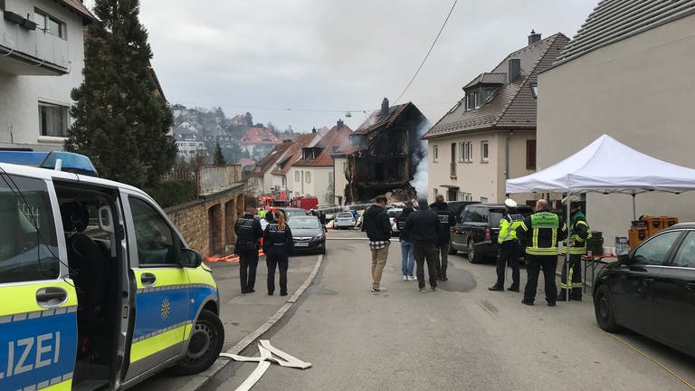 Polizei und Rettungskräfte stehen in der Nähe des ausgebrannten Wohnhauses in Stuttgart.  (Foto: SWR, Katharina Kurtz)