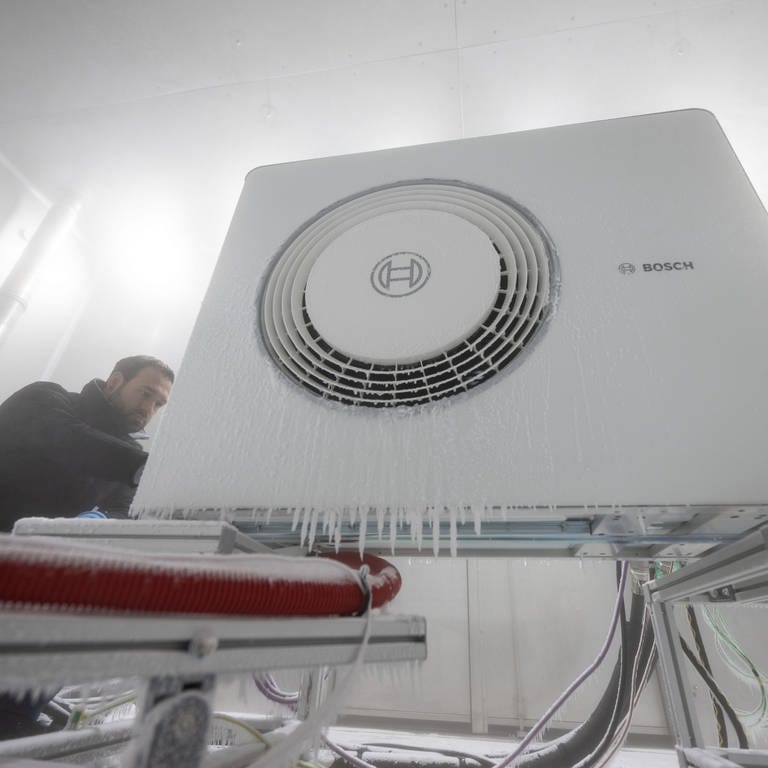 Bosch-Mitarbeiter öffnet Klimakammer einer Wärmepumpe (Foto: dpa Bildfunk, picture alliance/dpa | Marijan Murat)