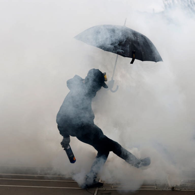 Ein Demonstrant wirft einen Tränengaskanister, während eines Zusammenstoßes mit der Polizei am Rande einer Demonstration in Frankreich. (Foto: dpa Bildfunk, picture alliance/dpa/AP | Jeremias Gonzalez)