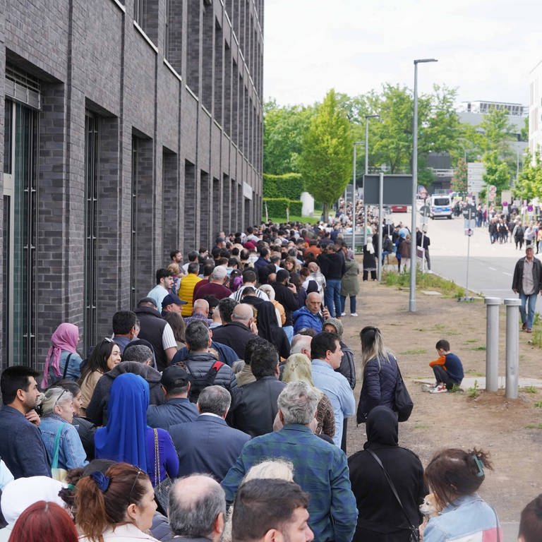 Eine lange Warteschlange hat sich vor dem Wahllokal in Stuttgart-Zuffenhausen gebildet. (Foto: dpa Bildfunk, picture alliance/dpa | Andreas Rosar)