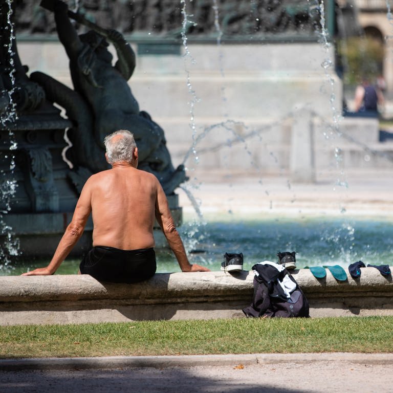 Ein Mann kühlt sich bei heißen Temperaturen an einem Brunnen in der Stuttgarter Innenstadt ab. (Foto: dpa Bildfunk, Picture Alliance)