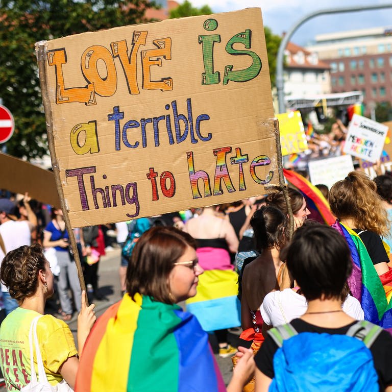 "Love is a terrible thing to hate" steht auf einem Schild bei der CSD-Demonstration in Stuttgart (Archivbild). (Foto: dpa Bildfunk, picture alliance/dpa | Christoph Schmidt)