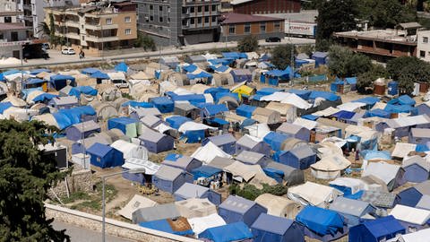 Blaue Zelte stehen mitten in der türkischen Stadt Antakya. Eine provisorische Zeltstadt für Menschen, die bei den Erdbeben in Februar ihre Häuser verloren hatten. (Foto: dpa Bildfunk, picture alliance/dpa | Bradley Secker)