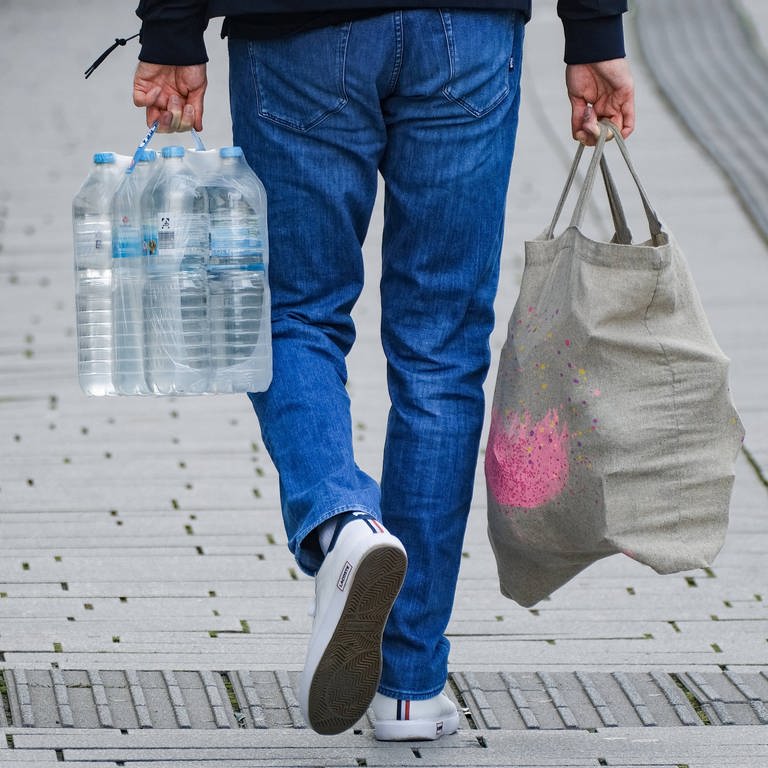 Mann trägt Wasser-Sixpack (Foto: IMAGO, Michael Gstettenbauer)