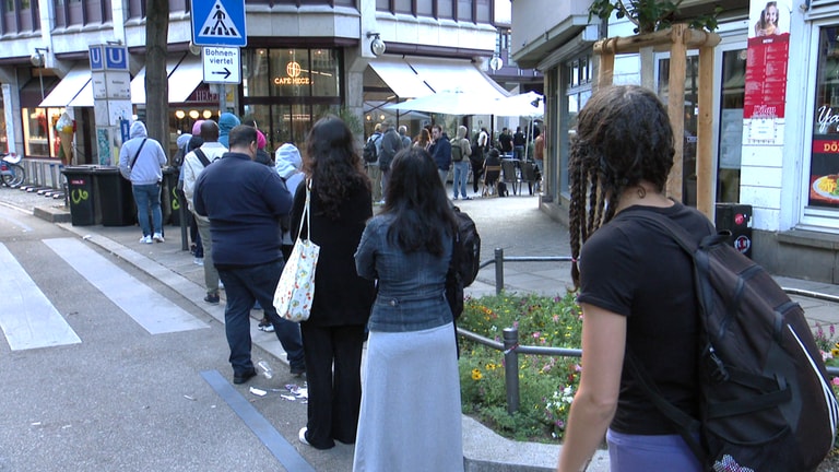 Menschen, die zur Ausländerbehörde in Stuttgart wollen, stehen Schlange bis auf die Eberhardstraße. (Foto: SWR)