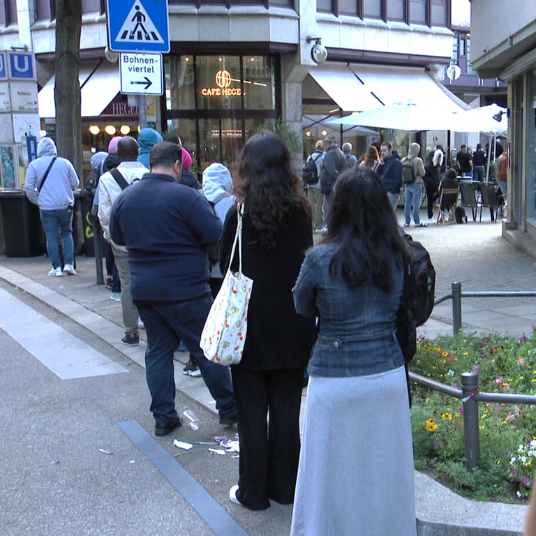 Menschen, die zur Ausländerbehörde in Stuttgart wollen, stehen Schlange bis auf die Eberhardstraße. (Foto: SWR)