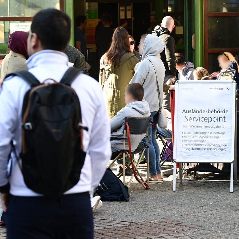Jeden Tag warten Menschen schon Stunden vor der Öffnung vor dem Eingang der Ausländerbehörde Stuttgart. Nun will Trumpf die Stadt unterstützen, um den Engpass zu beseitigen. (Foto: dpa Bildfunk, picture alliance/dpa | Bernd Weißbrod)