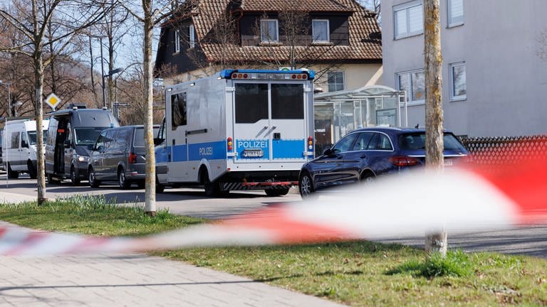 Vor Wohnhäusern in Reutlingen stehen mehrere Einsatzfahrzeuge der Polizei.