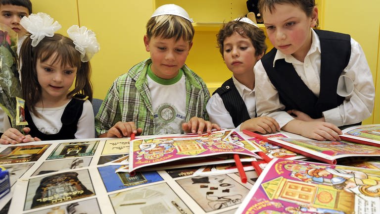 Jüdische Schüler betrachten während der Eröffnung der jüdischen Grundschule in Stuttgart bedruckte Papierbögen. (Foto: dpa Bildfunk, picture-alliance/ dpa | Marijan Murat)