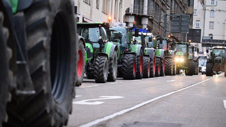 Viele Traktoren passieren hintereinander die Stuttgarter Innenstadt