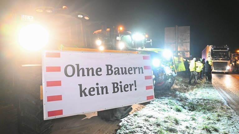 "Ohne Bauern kein Bier!" steht auf einem Plakat eines Landwirts beim Protest von Landwirten an der Zufahrt zur A8 bei Neuhausen (Kreis Esslingen). (Foto: dpa Bildfunk, picture alliance/dpa | Bernd Weißbrod)