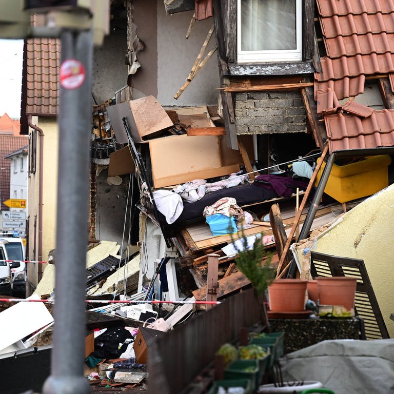 In Stuttgart-Vaihingen ist ein Wohnhaus explodiert: Trümmerteile liegen auf der Straße. Man kann ins Hausinnere sehen. 