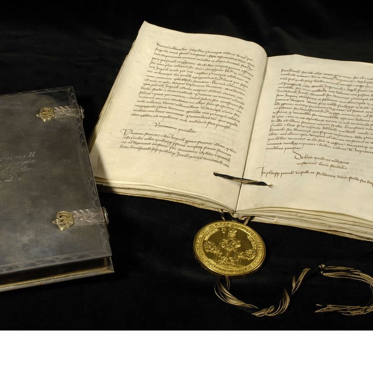 Die Goldene Bulle ausgebreitet auf einem Tisch. Das Dokument gilt als das "Grundgesetz" des Heiligen Römische Reichs. (Foto: Landesarchiv Baden-Württemberg)