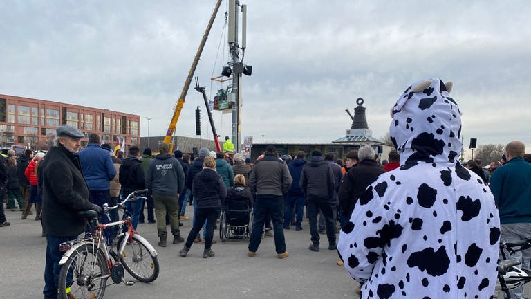 Ein Traktor hängt an einem Autokran über dem Canstatter Wasen - als weithin sichtbares Zeichen des Protestes: Landwirtinnen und Landwirte aus ganz Baden-Württemberg demonstrieren auf dem Cannstatter Wasen in Stuttgart. (Foto: SWR, Diana Hörger)