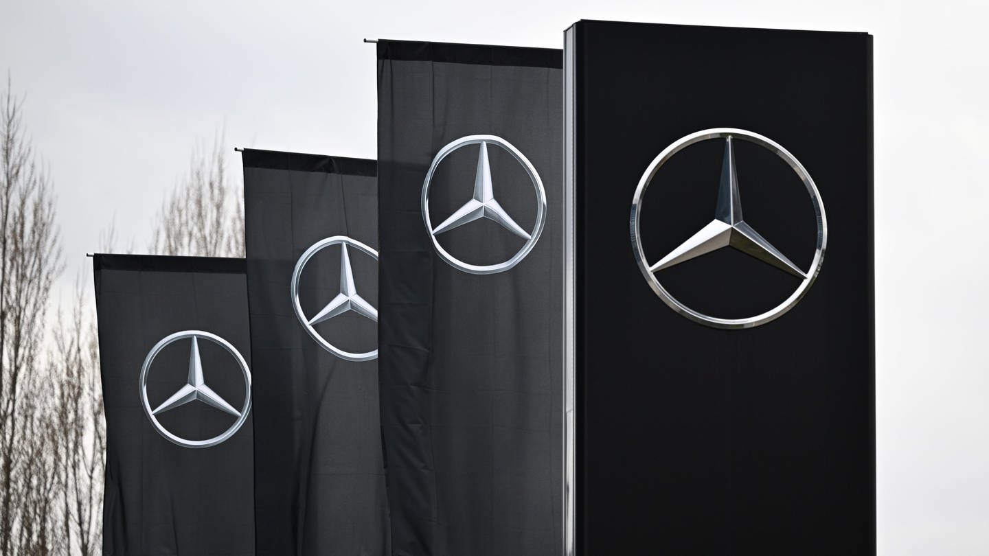 Das Logo der Automarke Mercedes-Benz weht an Fahnen vor einer Mercedes-Benz Niederlassung in Stuttgart. (Foto: dpa Bildfunk, picture alliance/dpa | Bernd Weißbrod)
