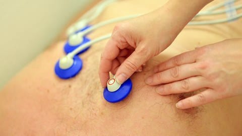 Einem Mann werden Elektroden für ein Elektrokardiogramm (EKG) angelegt. (Archivbild) (Foto: dpa Bildfunk, picture alliance/dpa | Maurizio Gambarini)