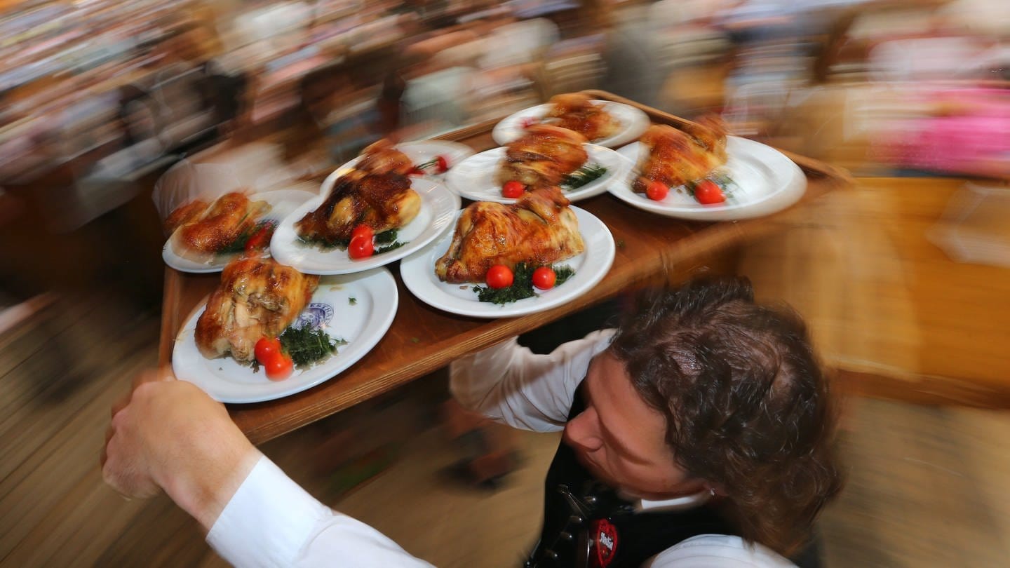 Essen wird durch ein Festzelt zu den Gästen gebracht. (Foto: dpa Bildfunk, picture alliance/dpa | Karl-Josef Hildenbrand)