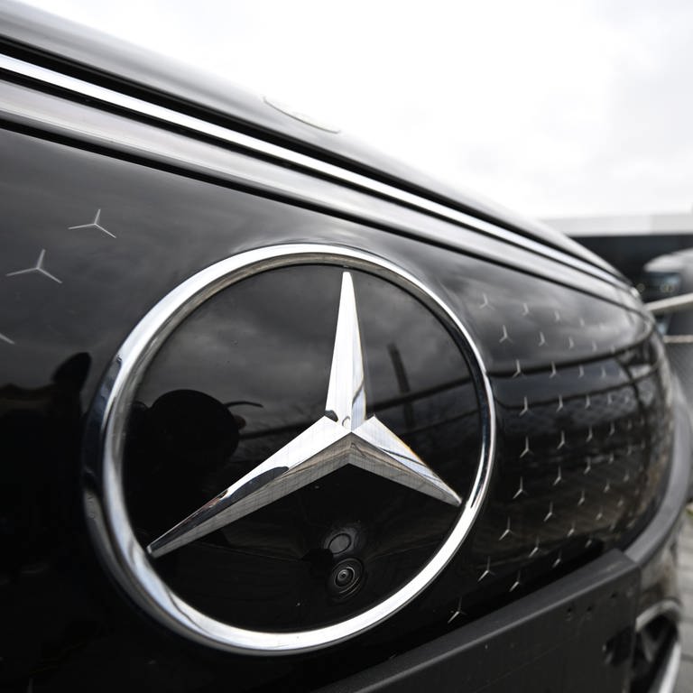 Vor einer Mercedes-Benz-Niederlassung steht ein Fahrzeug des Autobauers. Der Mercedes-Stern ist prominent im Vordergrund.