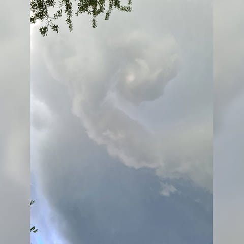 Wolken ziehen sich zu einer Spirale zusammen, aus der ein Tornado werden könnte.