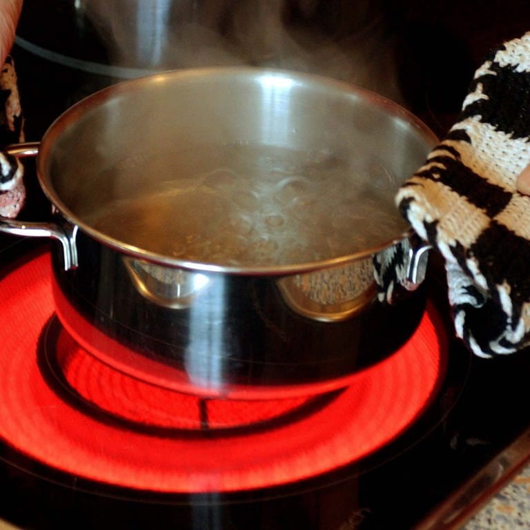In einem Kochtopf auf einem elektrischen Herd wird Wasser abgekocht.