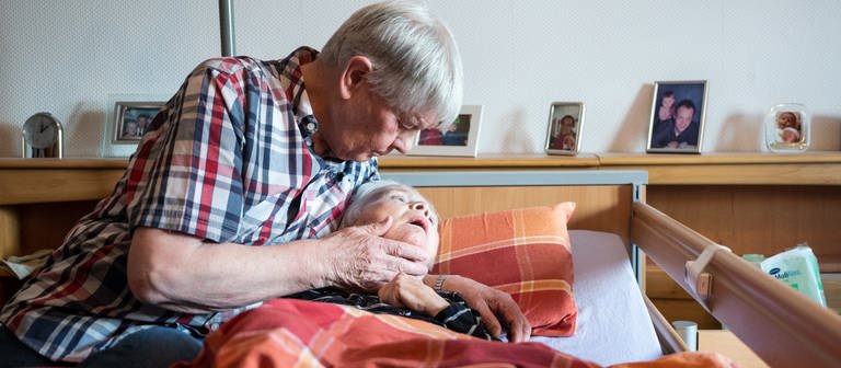 eine Frau liegt im Bett und wird umarmt (Foto: dpa Bildfunk, Bernd Thissen)