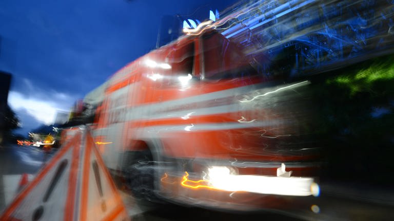 Ein Feuerwehrfahrzeug fährt in Bad Krozingen an einem Warnschild mit der Aufschrift "Feuerwehr" vorbei.  (Foto: dpa Bildfunk, Patrick Seeger)