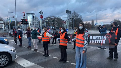 Demonstranten stehen mit  Transparenten "Essen retten - Leben retten" auf der Straße. (Foto: SWR, Dinah Steinbrink)