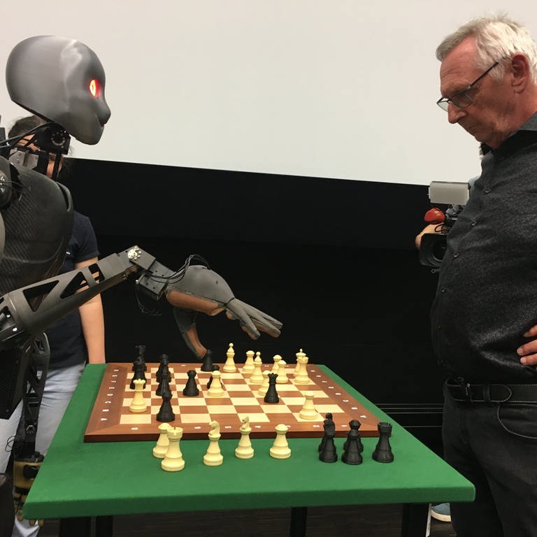 Roboter Sweaty und sein Gegner Michael Maly stehen am Schachbrett (Foto: SWR)