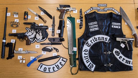Zahlreiche beschlagnahmte Waffen und eine Lederjacke der rockerähnlichen Gruppierung "United Tribuns" (Archivfoto). (Foto: dpa Bildfunk, Christoph Schmidt)