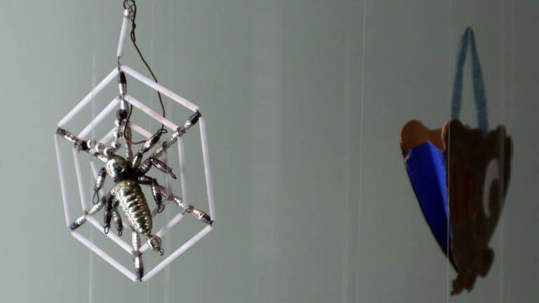 eine silberne Spinne im Netz, aus Perlen hergestellt (Foto: SWR, Laura Könsler)
