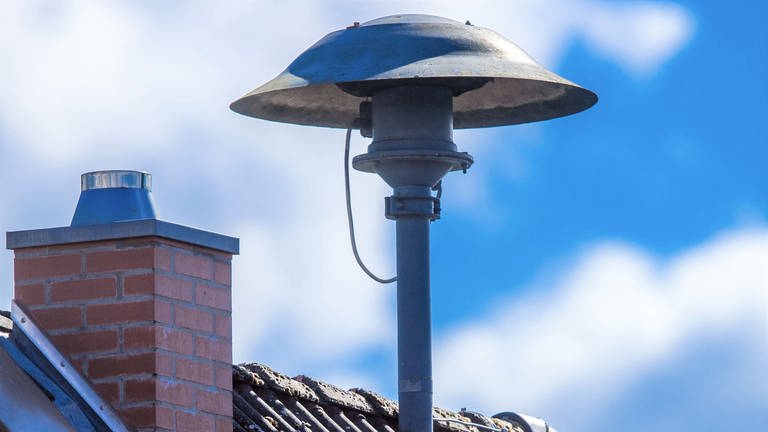Eine Alarmsirene steht auf einem Hausdach. (Foto: dpa Bildfunk, Jens Büttner)