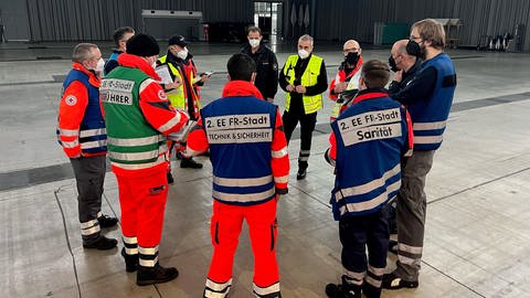 Lagebesprechung der Rettungsdienste zum provisorischen Behandlungsplatz in der Messe Freiburg (Foto: SWR)
