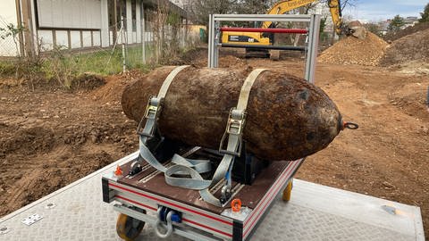 Ein gesicherter brauner Sprengkörper ist auf einem Transportwagen zu sehen. (Foto: SWR)