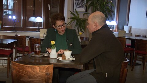 Eine Frau und ein Mann sitzen an einem Tisch in einem Café. (Foto: SWR)