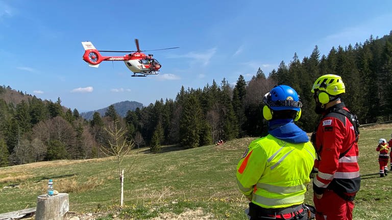 Zwei Helfer im Schwarzwald beobachten den Hubschrauber in der Nähe. (Foto: SWR, Ina Held)