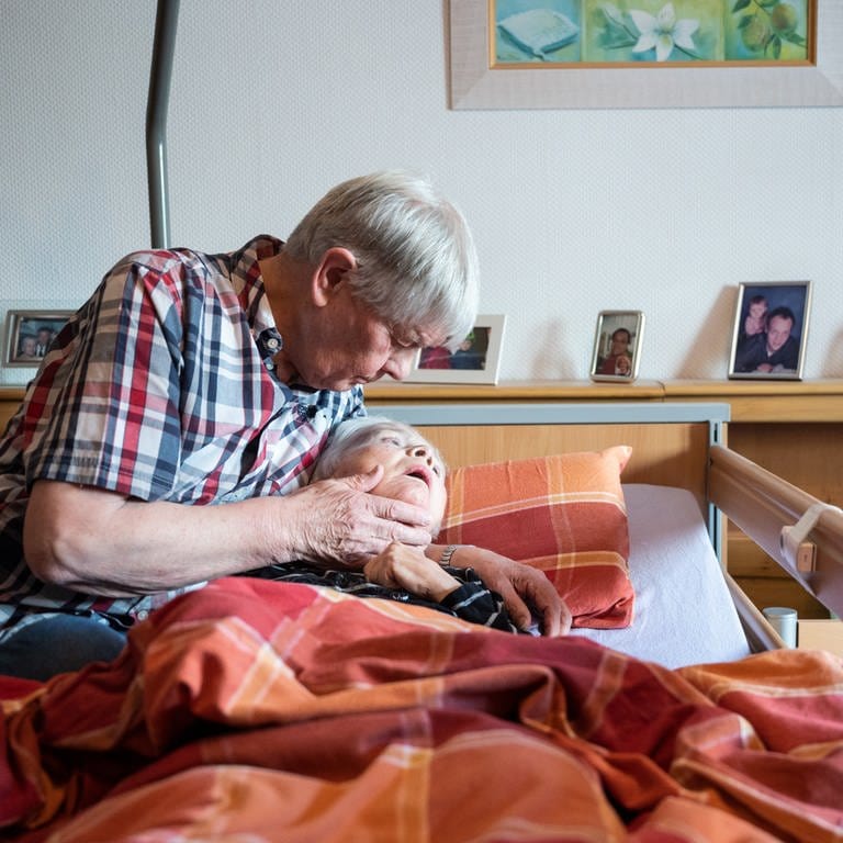 eine Frau liegt im Bett und wird umarmt (Foto: dpa Bildfunk, Bernd Thissen)